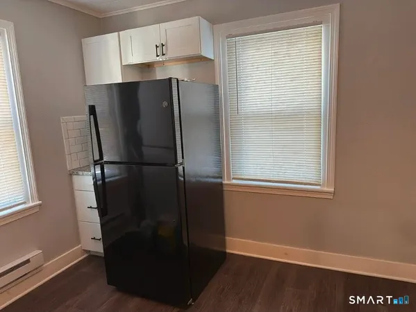 a kitchen with metallic refrigerator and window