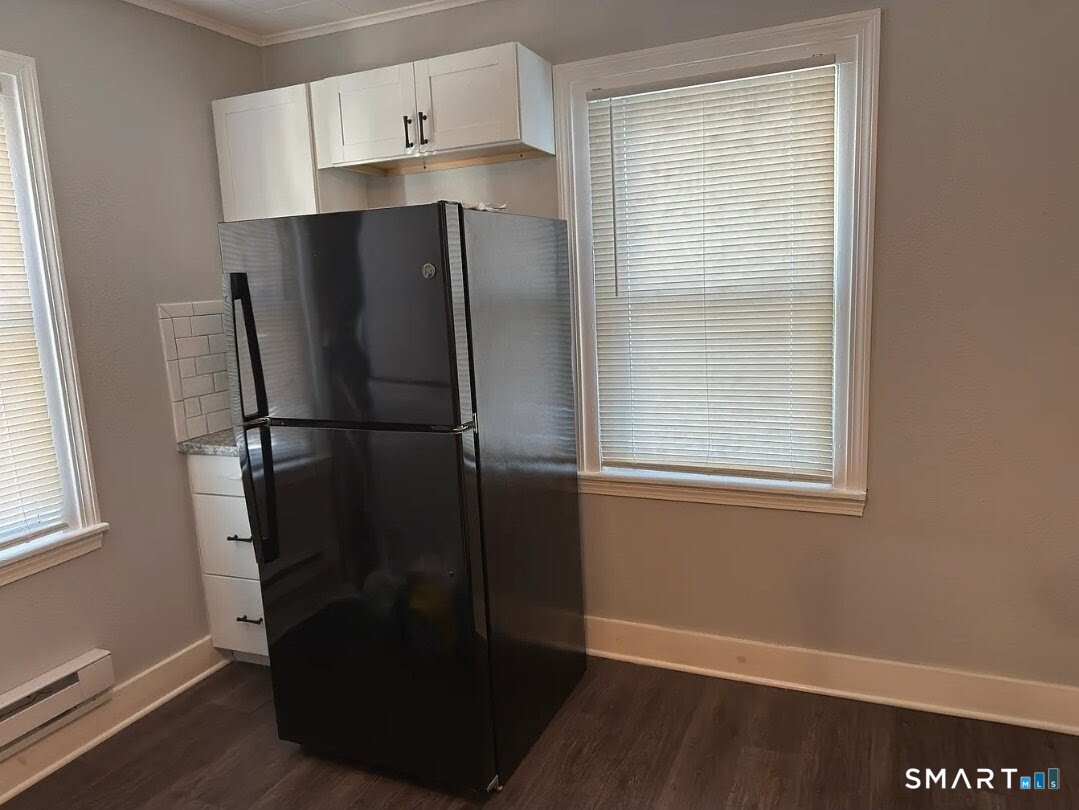 1163 West Main Street Waterbury, CT 06708 - Photo 3 of 11 a kitchen with metallic refrigerator and window