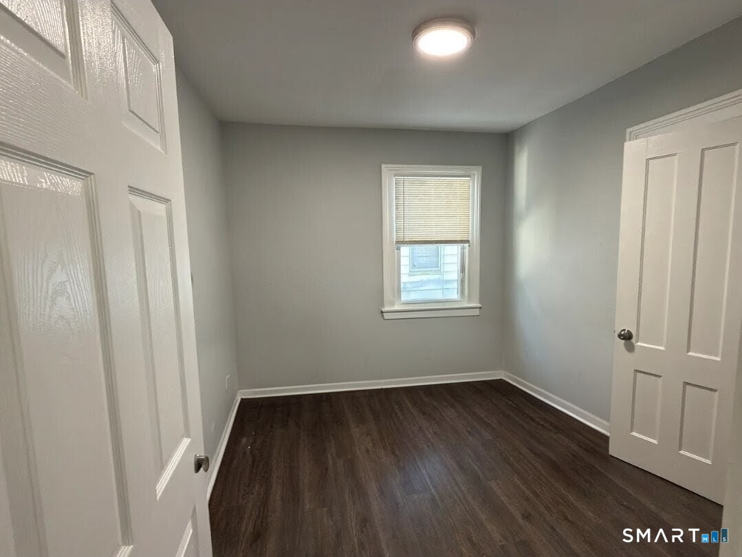 1163 West Main Street Waterbury, CT 06708 - Photo 6 of 11 an empty room with wooden floor and windows
