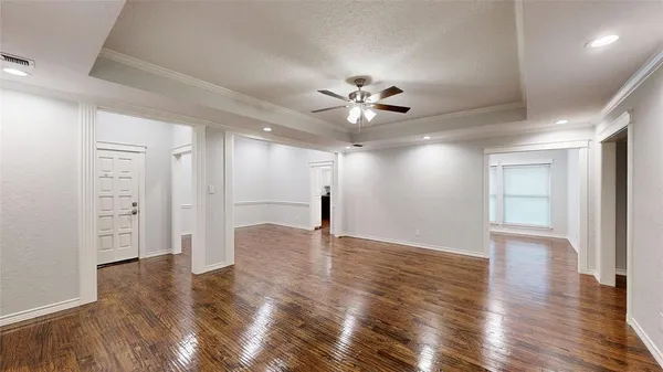 a view of an empty room with wooden floor