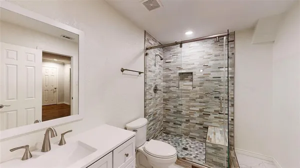 a bathroom with a sink toilet and shower