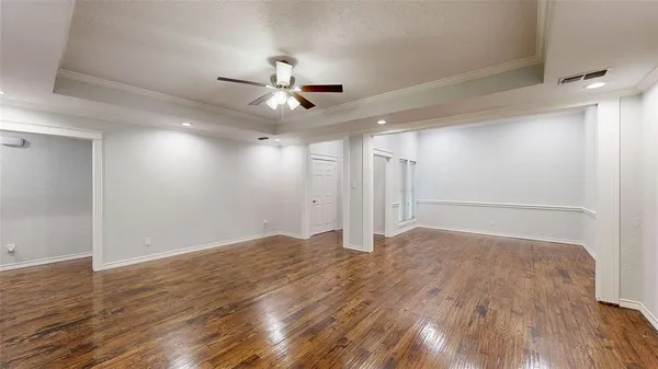 a view of an empty room with wooden floor