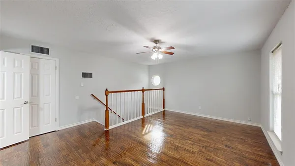 a view of an empty room with wooden floor