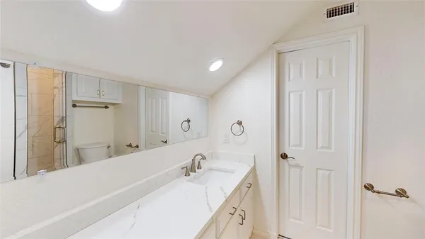 a bathroom with a granite countertop sink a mirror and a bathtub
