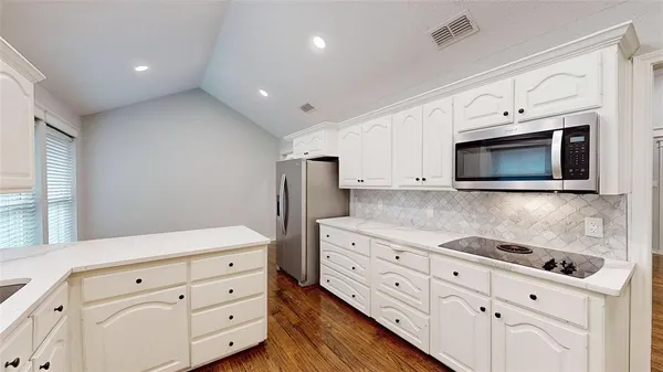 a kitchen with granite countertop white cabinets white stainless steel appliances and sink