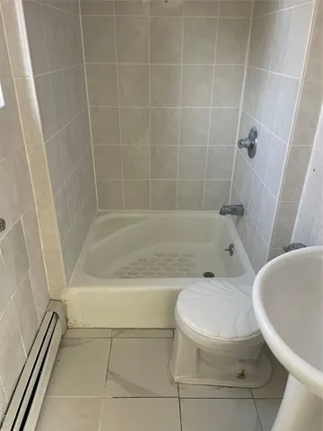 a white toilet sitting next to a bath tub