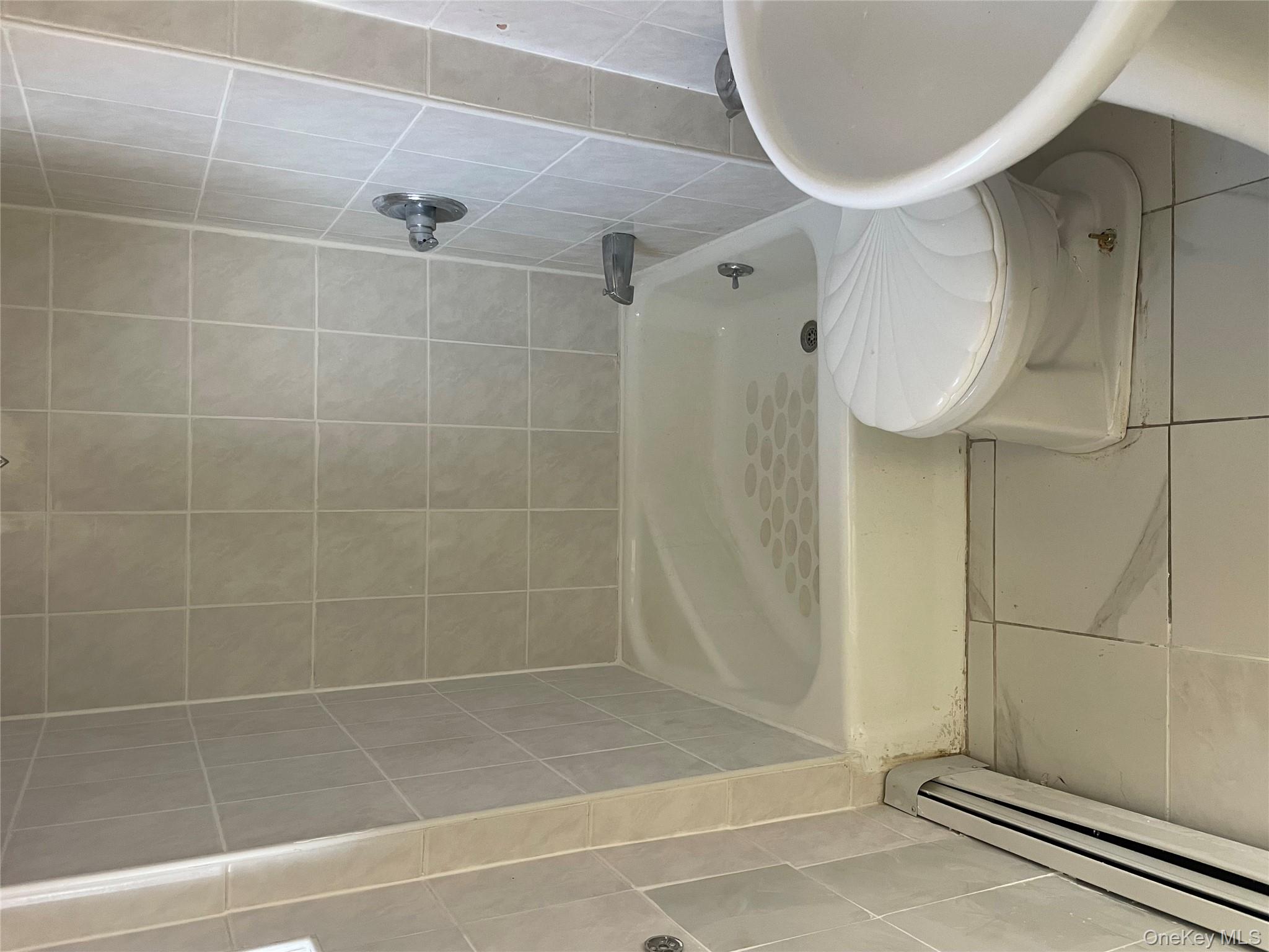 95-12 67th Avenue, Unit 2F Queens, NY 11375 - Photo 7 of 9 Bathroom with baseboard heating and tile patterned floors