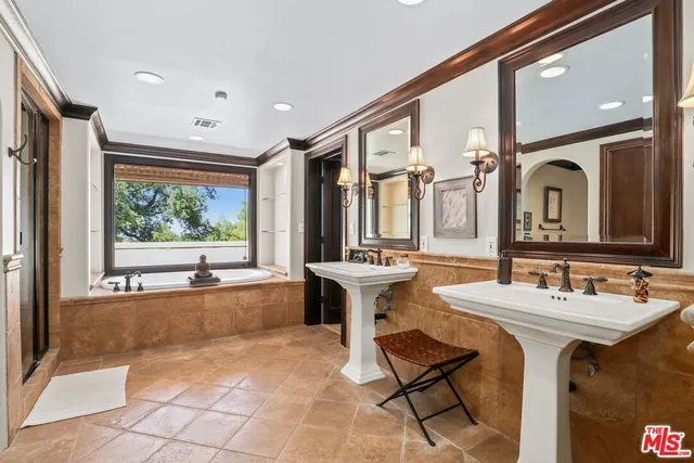 a spacious bedroom with a bed and a chandelier