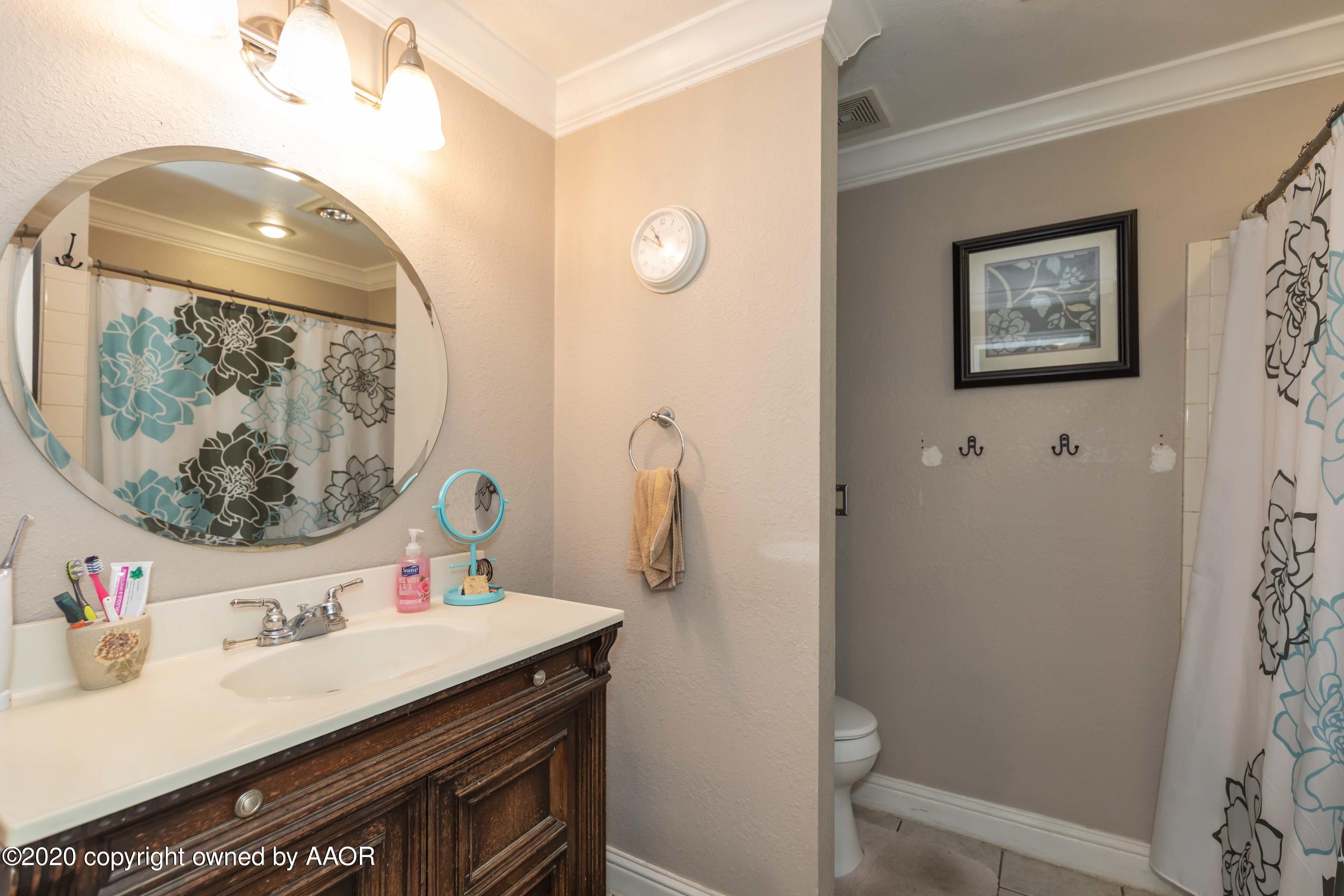 3505 South Tyler Street Amarillo, TX 79110 - Photo 21 of 29 a bathroom with a sink a mirror and a toilet