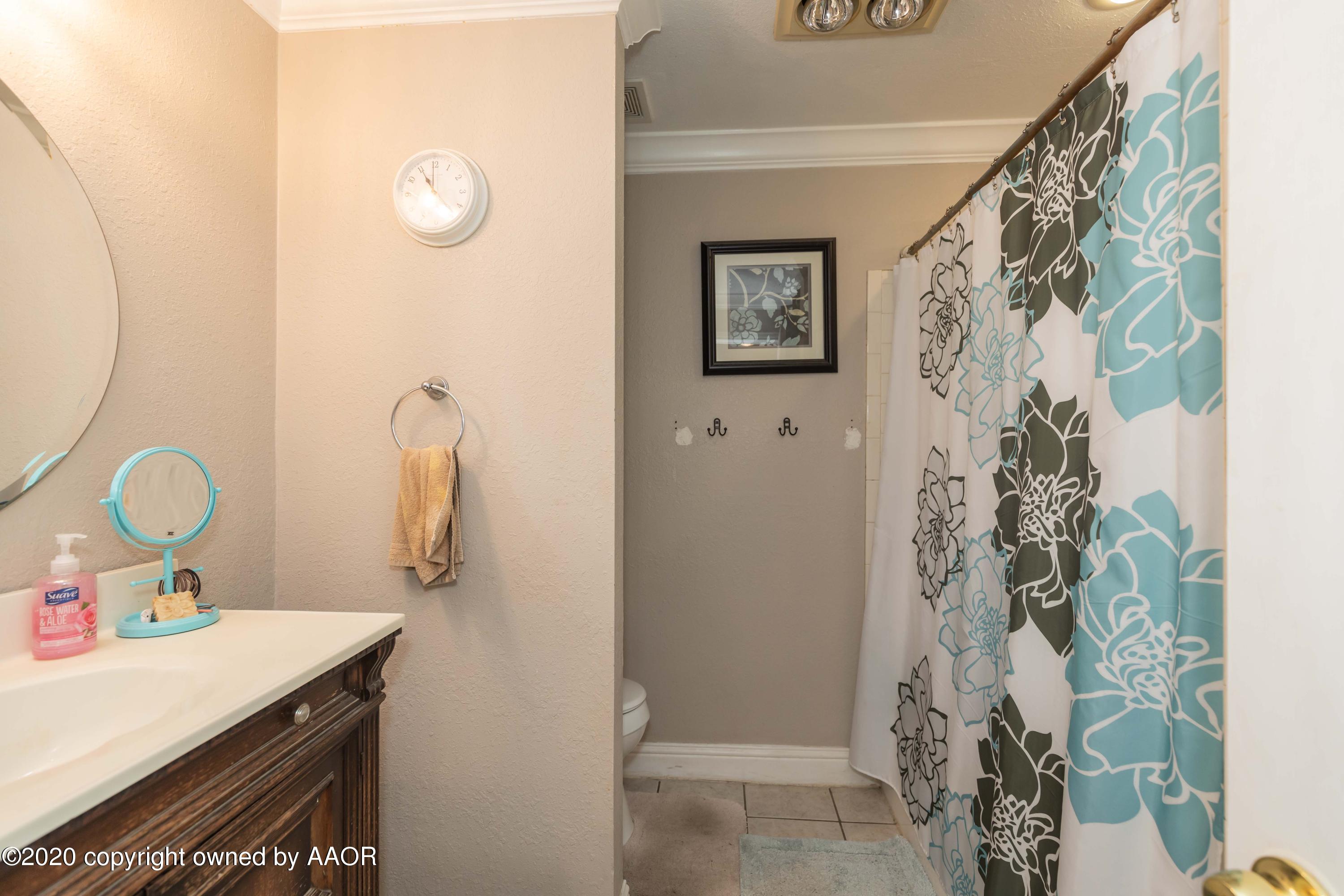 3505 South Tyler Street Amarillo, TX 79110 - Photo 22 of 29 a bathroom with a sink and mirror with toilet