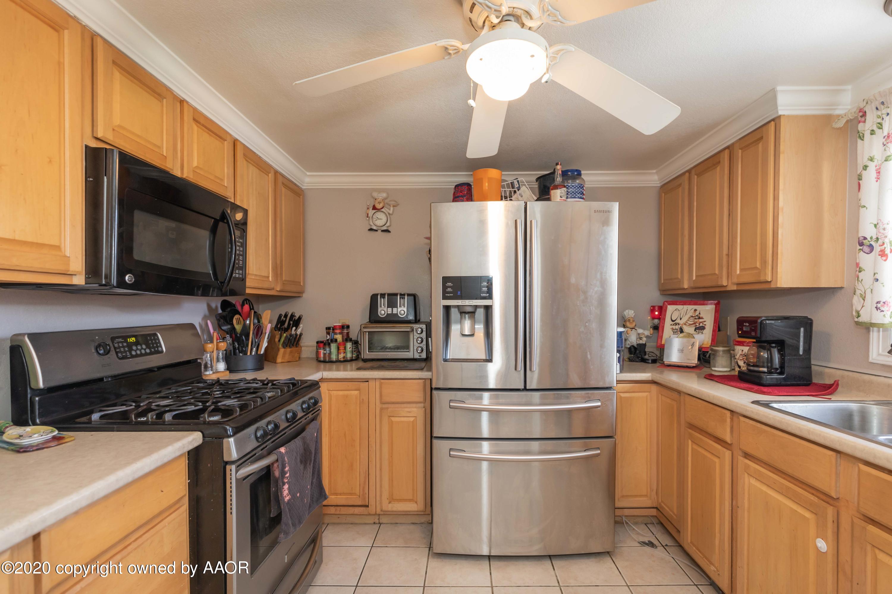 3505 South Tyler Street Amarillo, TX 79110 - Photo 10 of 29 a kitchen with stainless steel appliances granite countertop a refrigerator stove a sink dishwasher and microwave with wooden floor