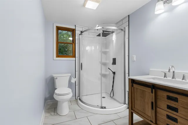 a bathroom with a granite countertop sink toilet and shower