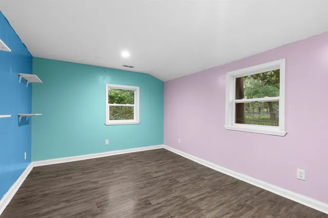 a view of a big room with wooden floor and windows