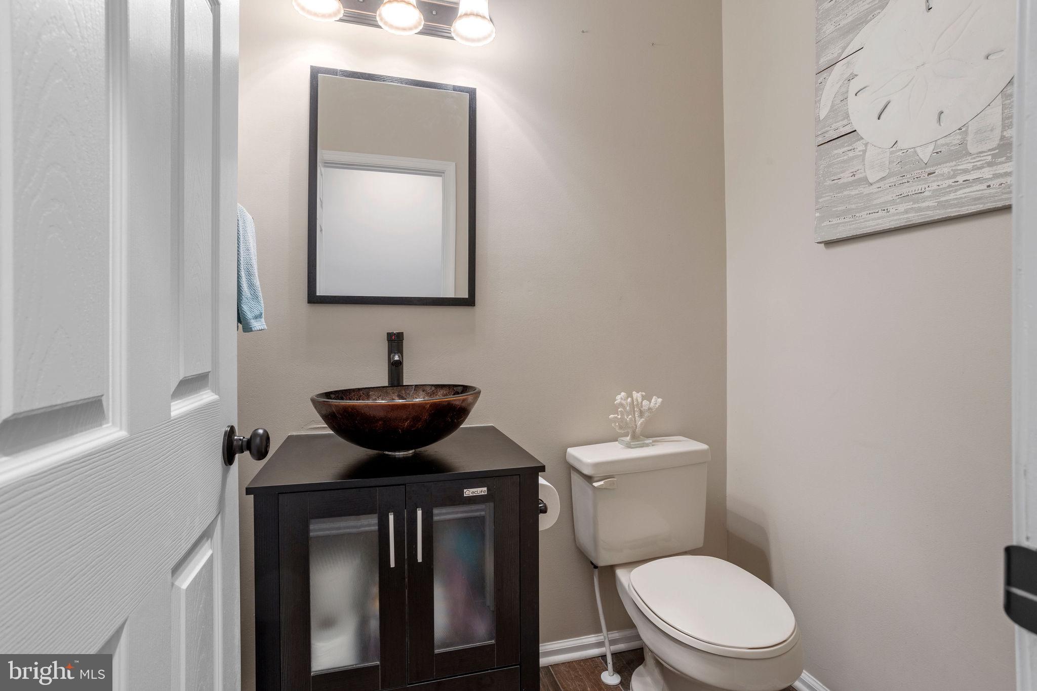 233 Windsor Drive Swedesboro, NJ 08085 - Photo 18 of 46 a bathroom with a toilet a sink and mirror