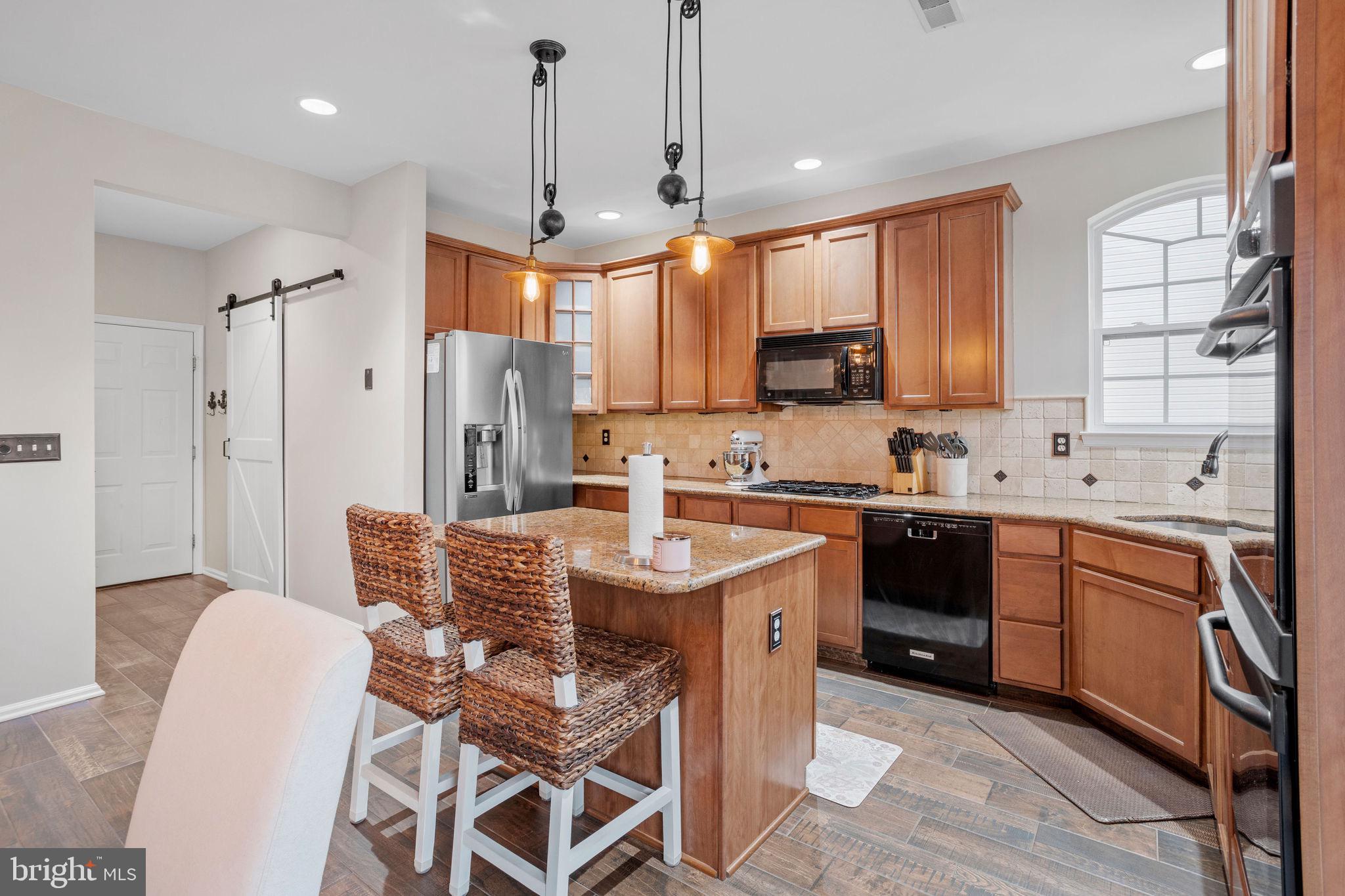 233 Windsor Drive Swedesboro, NJ 08085 - Photo 8 of 46 a kitchen with stainless steel appliances kitchen island granite countertop a sink a stove a refrigerator and island with wooden floor