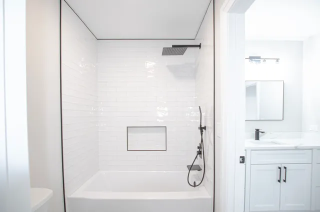 a bathroom with a tub shower vanity and a sink
