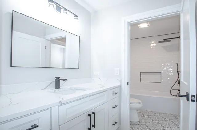 a bathroom with a sink a toilet and shower