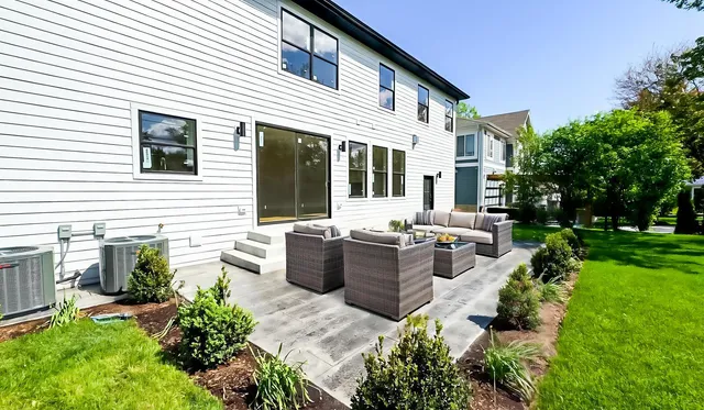 a view of a house with backyard and sitting area