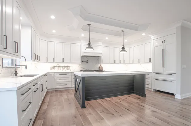 a kitchen with stainless steel appliances kitchen island granite countertop a sink cabinets and wooden floor
