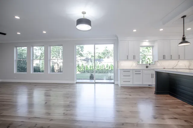 a kitchen with stainless steel appliances granite countertop a stove a sink and a large window