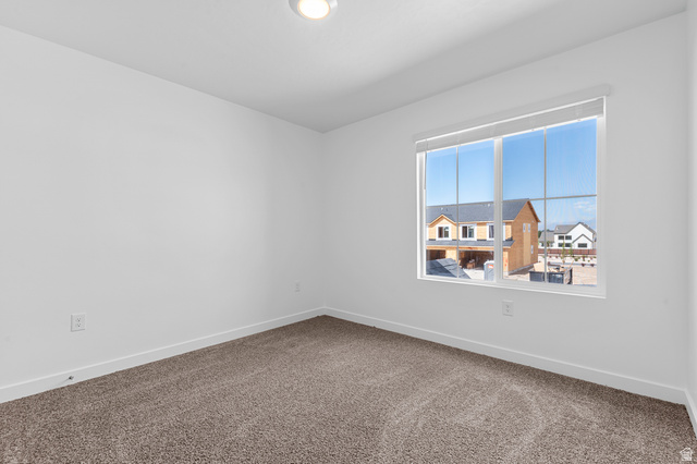 1907 East 640th North, Unit 1225 Salem, UT 84653 - Photo 10 of 20 Carpeted room featuring a large window with roller shades, white walls, and bright overhead lighting