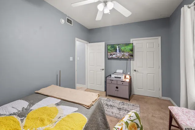 a bedroom with a bed and ceiling fan
