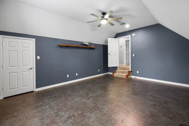 an empty room with closet and fan