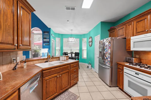 a kitchen with stainless steel appliances granite countertop a refrigerator and a sink