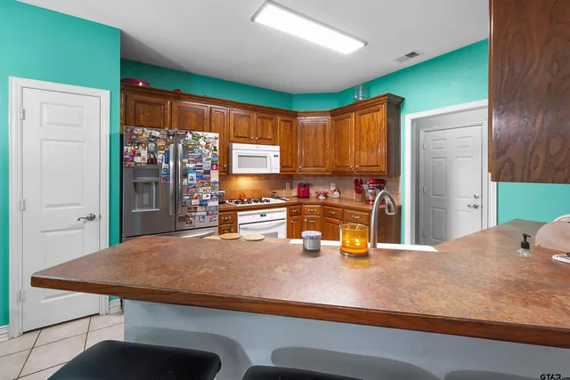 a kitchen with a sink a counter top space stainless steel appliances and cabinets