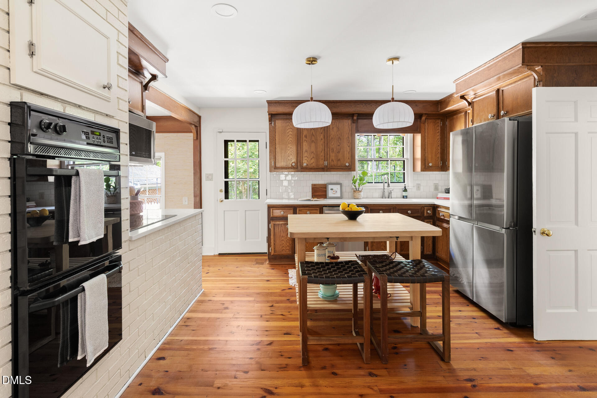 1706 Wallace Street Durham, NC 27707 - Photo 19 of 55 a kitchen with stainless steel appliances a dining table chairs stove refrigerator and microwave