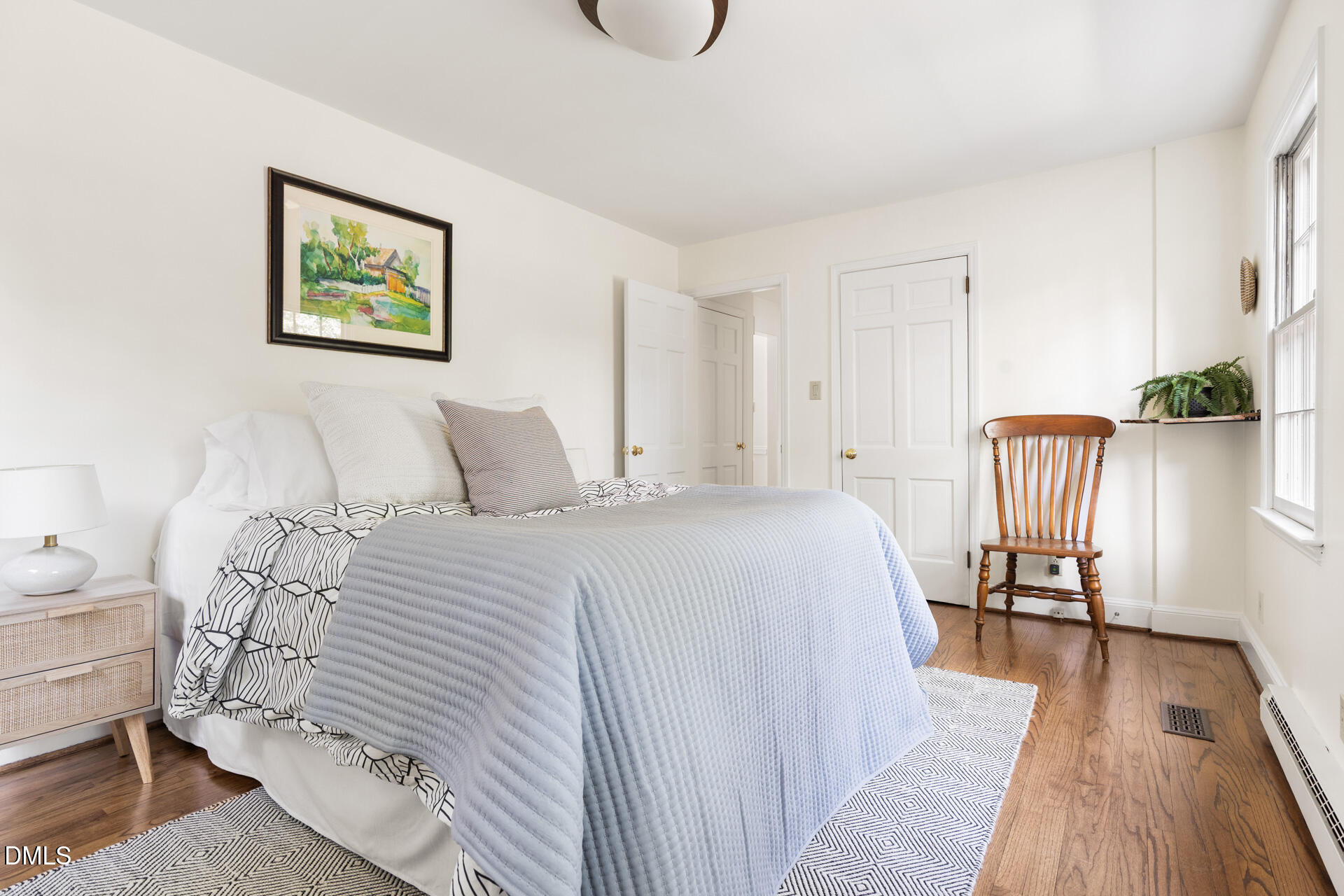 1706 Wallace Street Durham, NC 27707 - Photo 29 of 55 a bedroom with a bed and a table with wooden floor