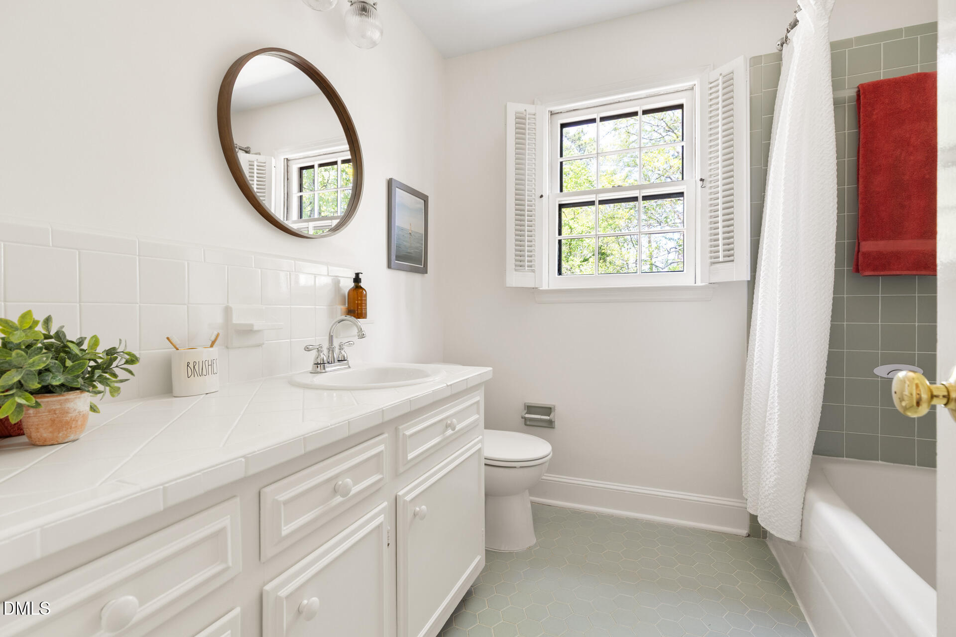 1706 Wallace Street Durham, NC 27707 - Photo 41 of 55 a bathroom with a sink a mirror a toilet and a window
