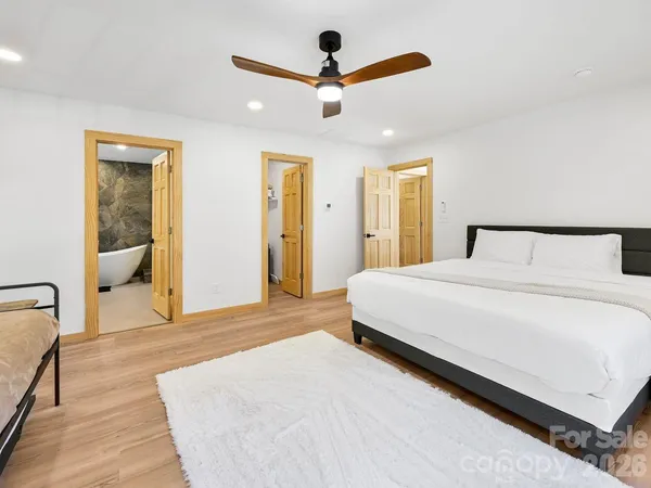 a bedroom with a large bed and a chandelier