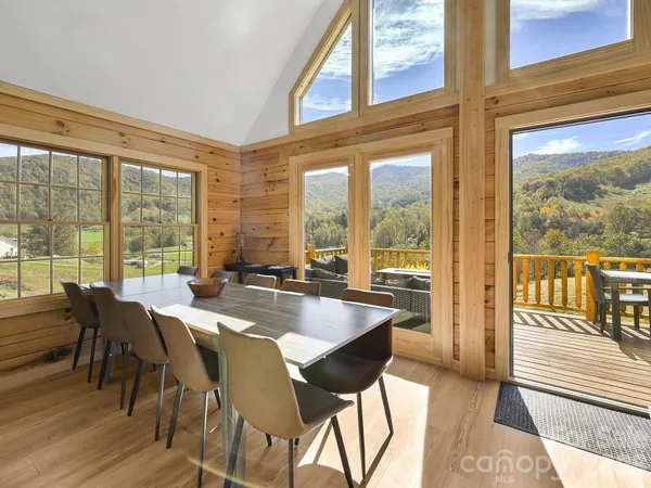 a view of a dining room with furniture and large windows