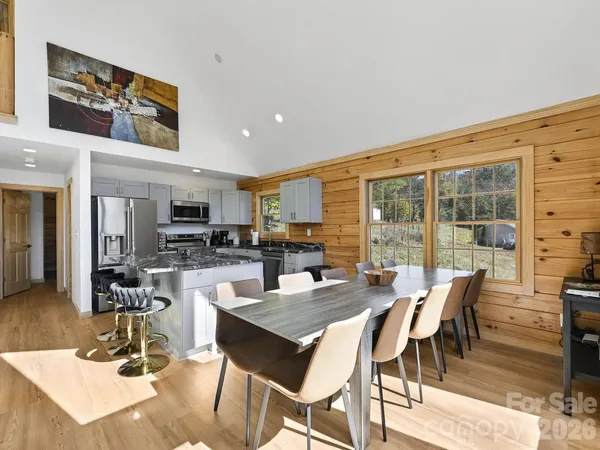 a living room with stainless steel appliances kitchen island granite countertop a table chairs and a kitchen view