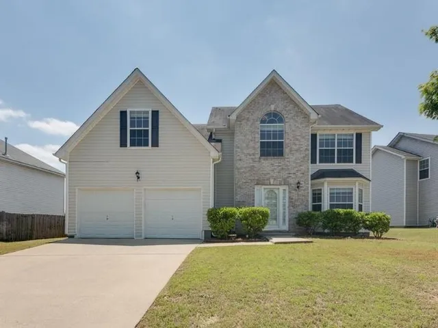 a front view of a house with a yard and garage
