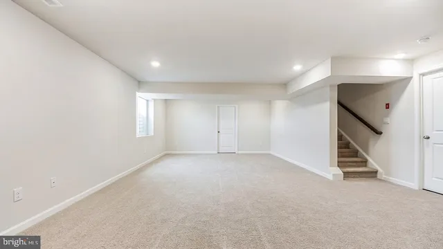 an empty room with staircase and white walls