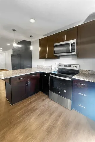 a kitchen with stainless steel appliances granite countertop a sink and a stove