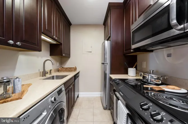 a view of a kitchen with kitchen island a sink wooden floor and a refrigerator