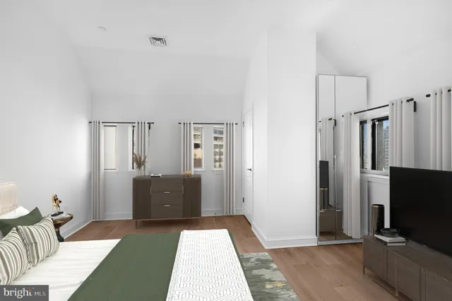 a bedroom with furniture and a flat screen tv