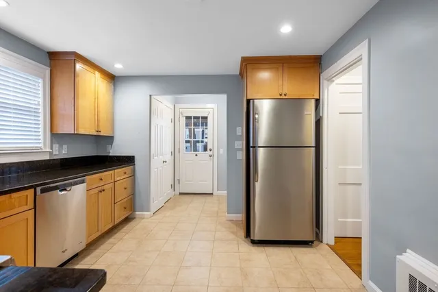 a kitchen with stainless steel appliances granite countertop a refrigerator a sink and a stove
