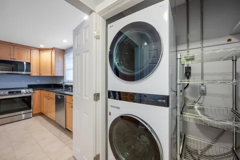 a kitchen with stainless steel appliances granite countertop a sink a stove a refrigerator and a microwave