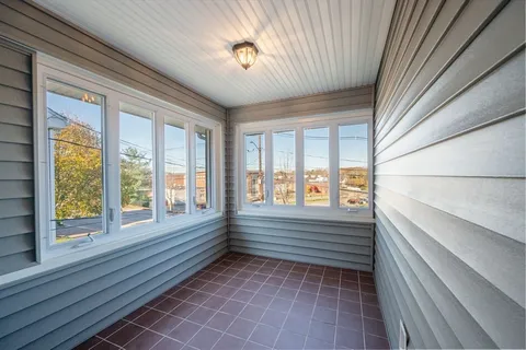 a view of front door with furniture and windows