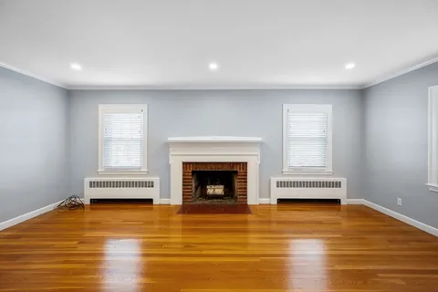 a living room with a fireplace and a ceiling fan
