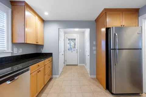 a kitchen with stainless steel appliances granite countertop a refrigerator and a stove