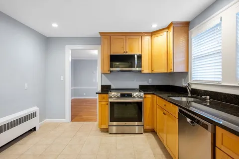 a kitchen with granite countertop a sink and a stove top oven