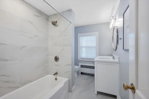 a bathroom with a tub sink and mirror