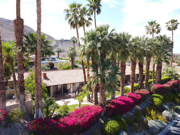 a front view of a house with a yard and mountain view