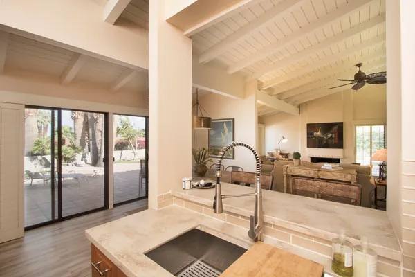 a kitchen with stainless steel appliances a stove a sink dishwasher a refrigerator white cabinets and wooden floor