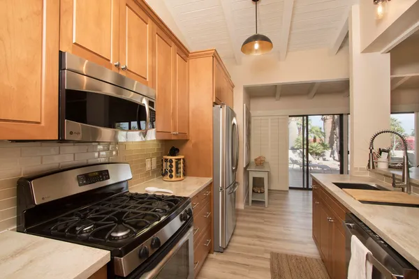 a kitchen with granite countertop a refrigerator stove and microwave